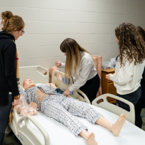 Health Academy students practicing skills on a manikin